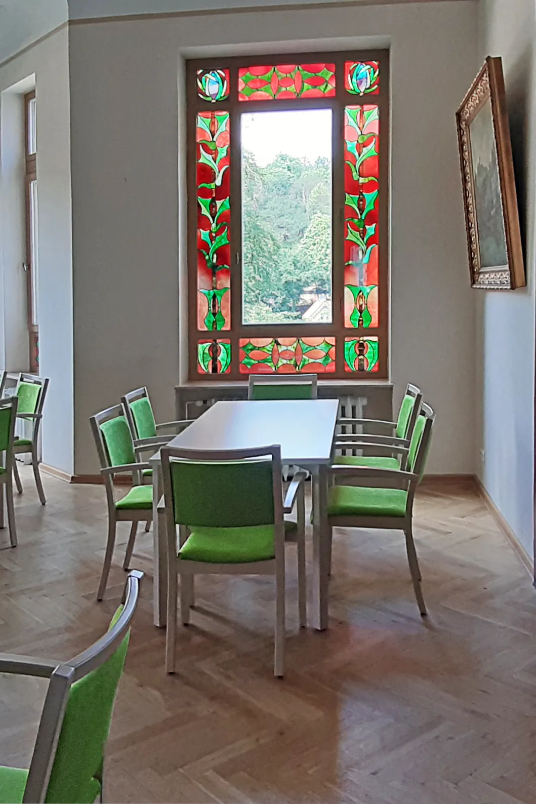 Gesprächsraum mit Tisch und grünen Stühlen in der Tagespflege Herzwohl