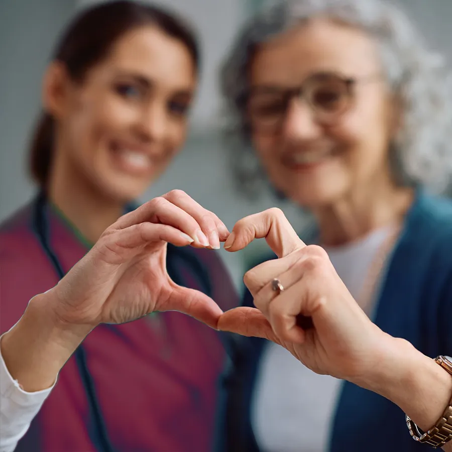 Zwei Hände formen ein Herzsymbol und stehen für Menschlichkeit, Teamgeist und Arbeiten mit Herz in der Pflege