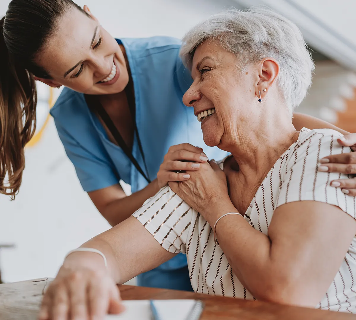 Pflegekraft von Herzwohl betreut eine Seniorin zuhause und unterstützt sie liebevoll im täglichen Pflegealltag