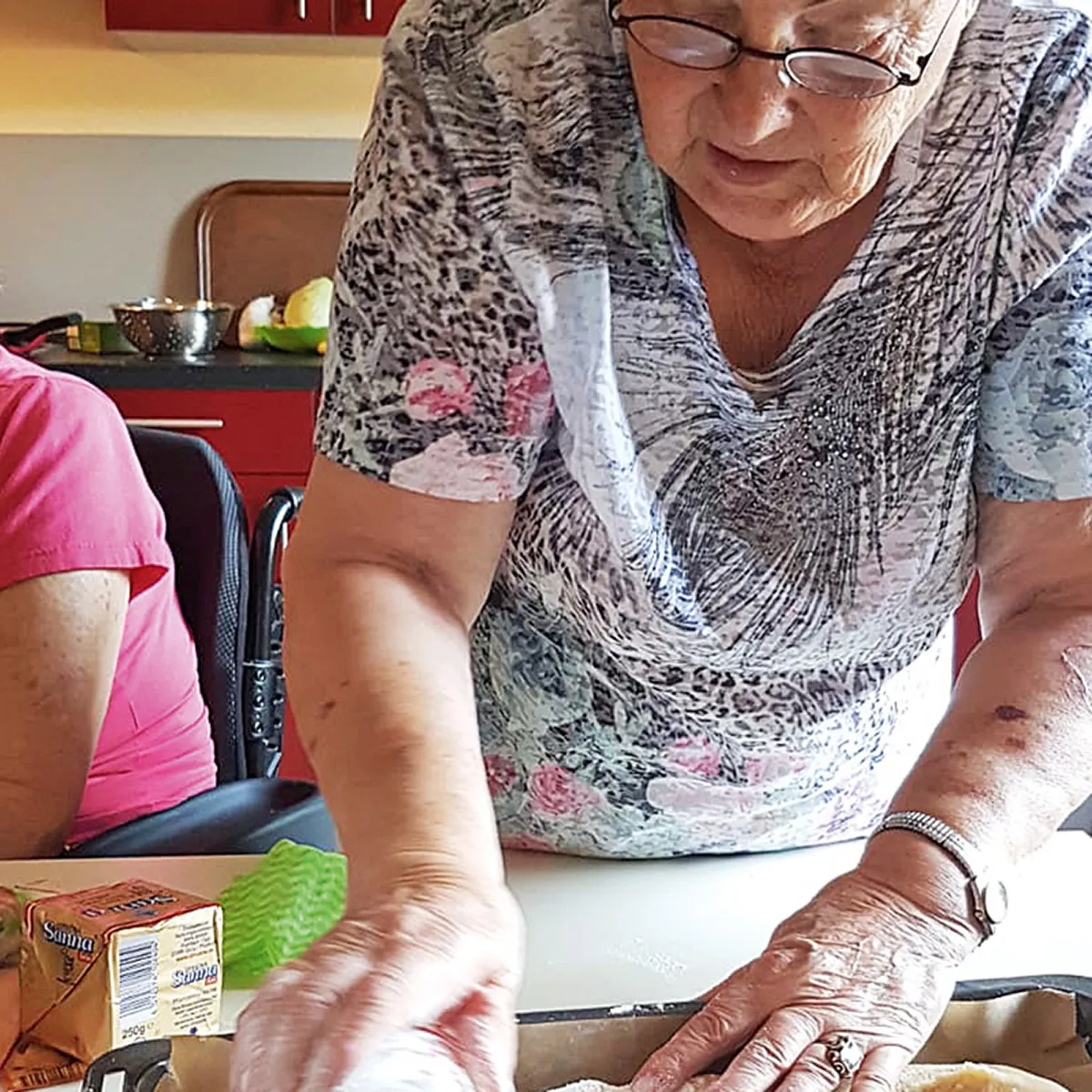 Seniorinnen bereiten zusammen eine Mahlzeit zu und erleben Gemeinschaft und Aktivität in der Tagespflege